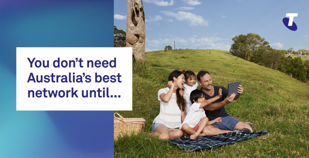 Group of friends on a blanket in a grassy park taking a selfie with a smartphone, beside a blue gradient advertisement panel.