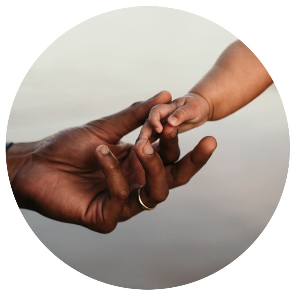 An adult hand and a child's hand reaching toward each other and touching.